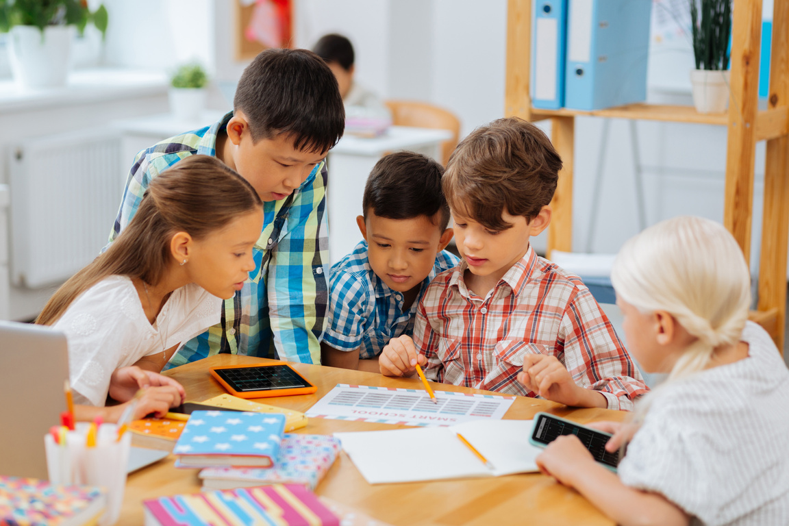 Company of classmates sitting together in a classroom